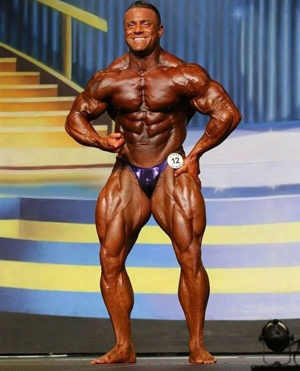 Brad Rowe posing on the bodybuilding stage.