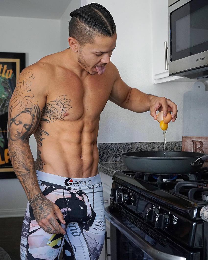 Brandon Schram cracking eggs into the stove looking fit and lean