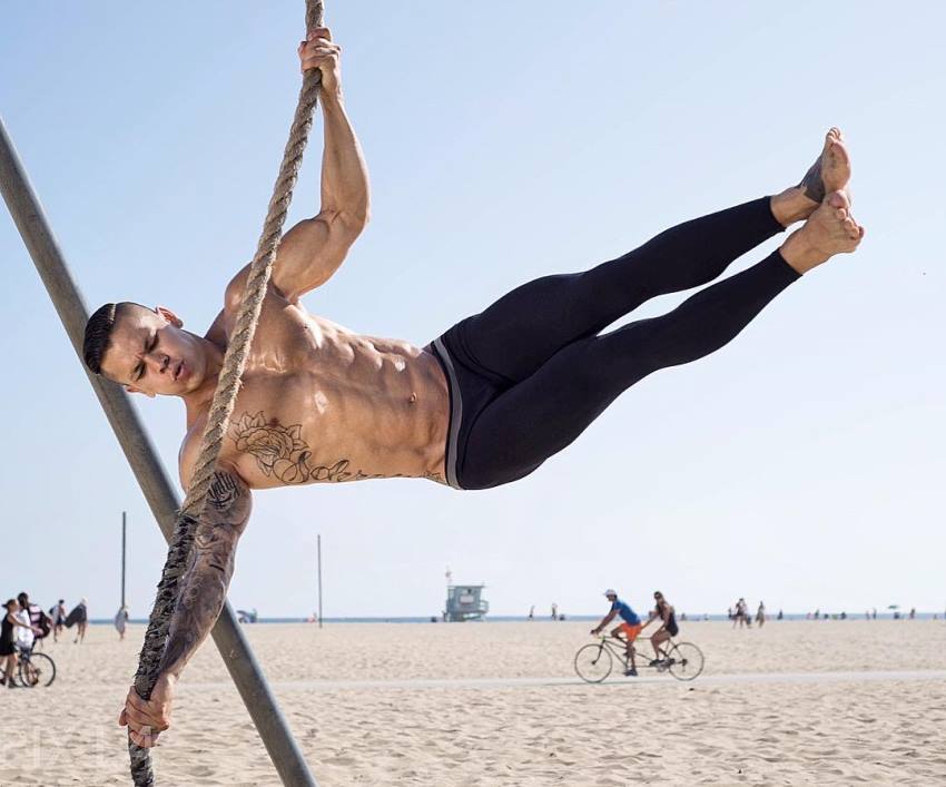 Brandon Schram performing tricks on the rope on the beach