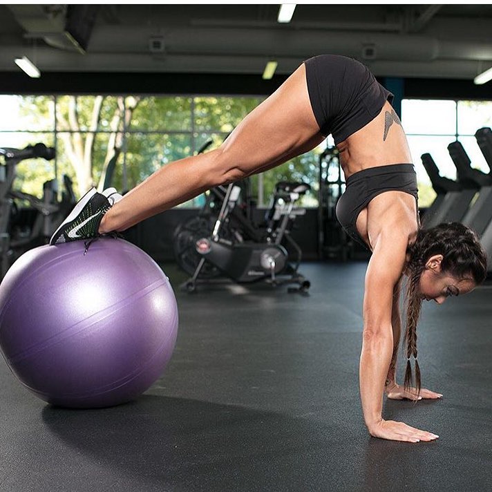 Caryn Nicole Paolini doing an exercise on a medicine ball