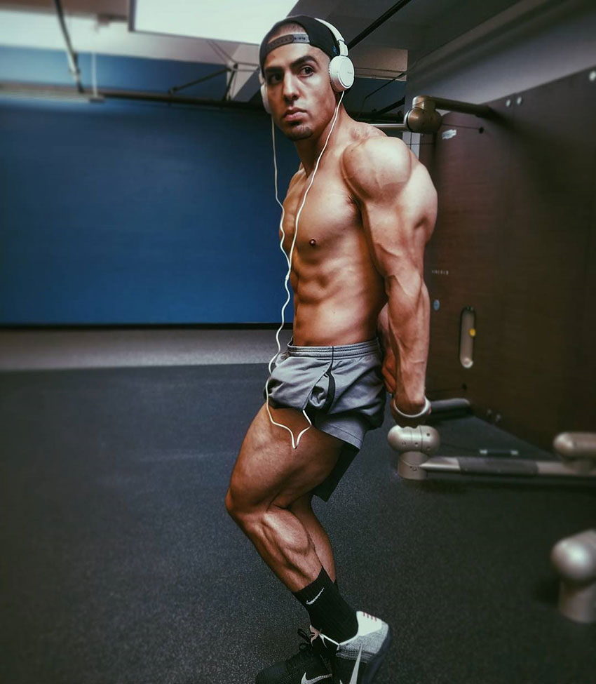 Chris Lavado posing, showing off his physique in the gym.