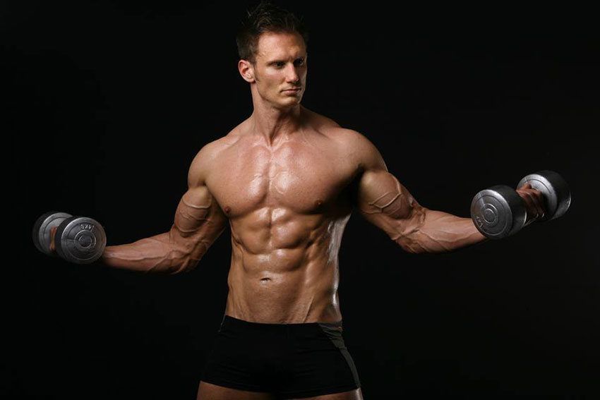 Dave Cunningham holding dumbbells in a photo shoot.