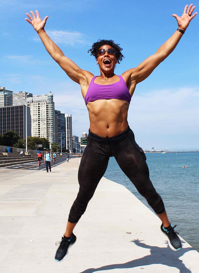 Elizabeth Akinwale jumping into the air next to the ocean.