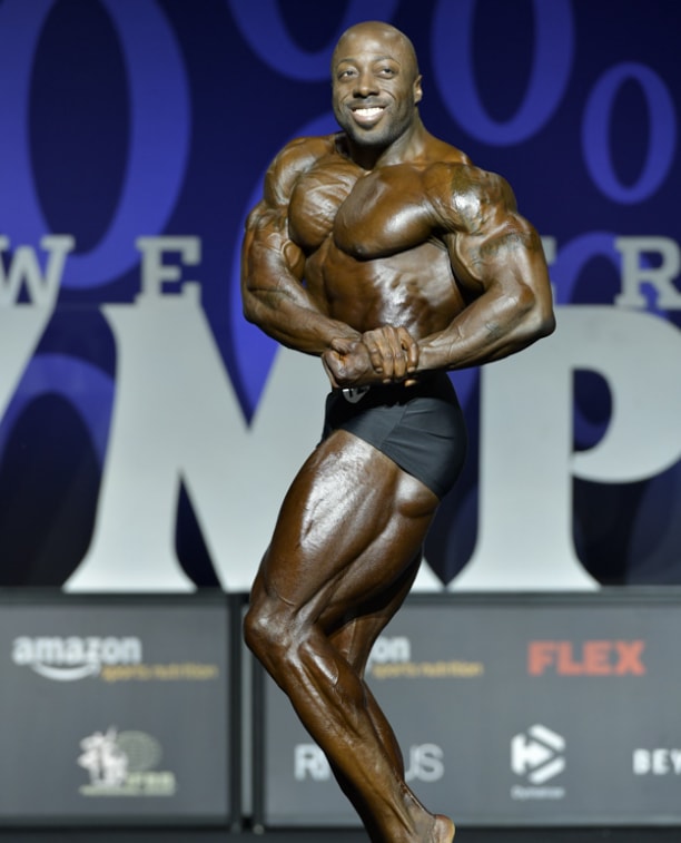 George Peterson showing off a side chest pose on the Classic Physique Olympia stage