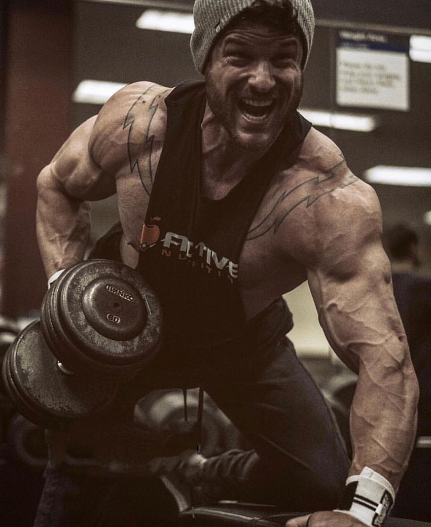 James Hurst performing dumbbell rows in the gym.