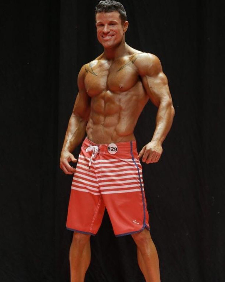 James Hurst posing on the fitness modelling stage.