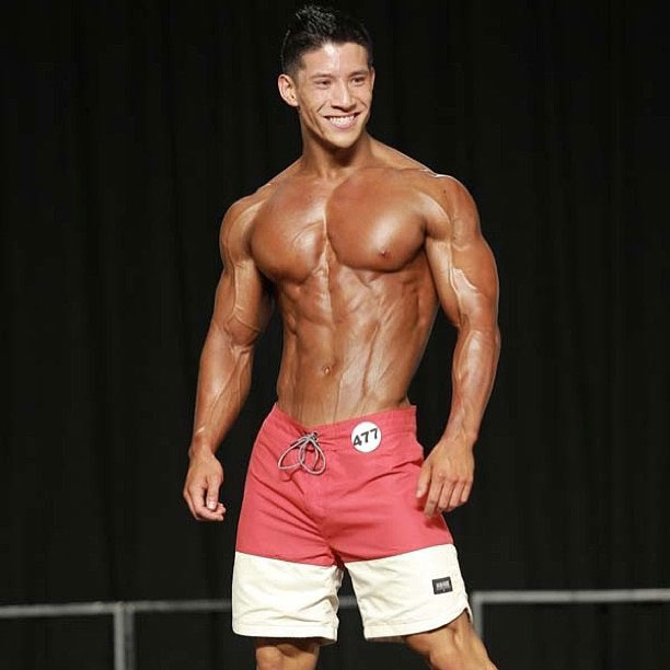 John Nguyen posing on the bodybuilding stage.