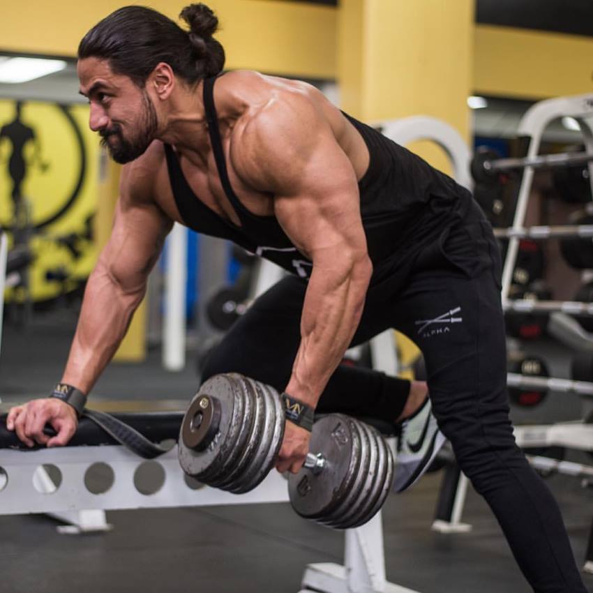 Justin Gonzales doing dumbbell bent-over rows, looking ripped and muscular