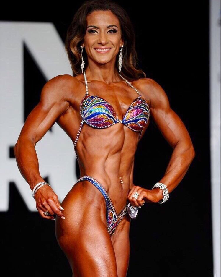 Maggie Corso posing on the bodybuilding stage.
