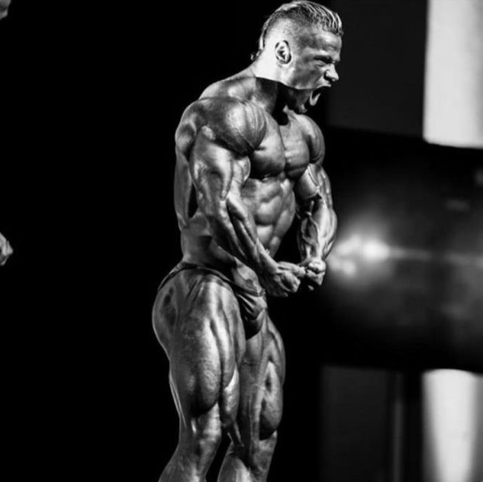 Side picture of Nicolas Vullioud doing a most muscular pose on the stage yelling at the audience