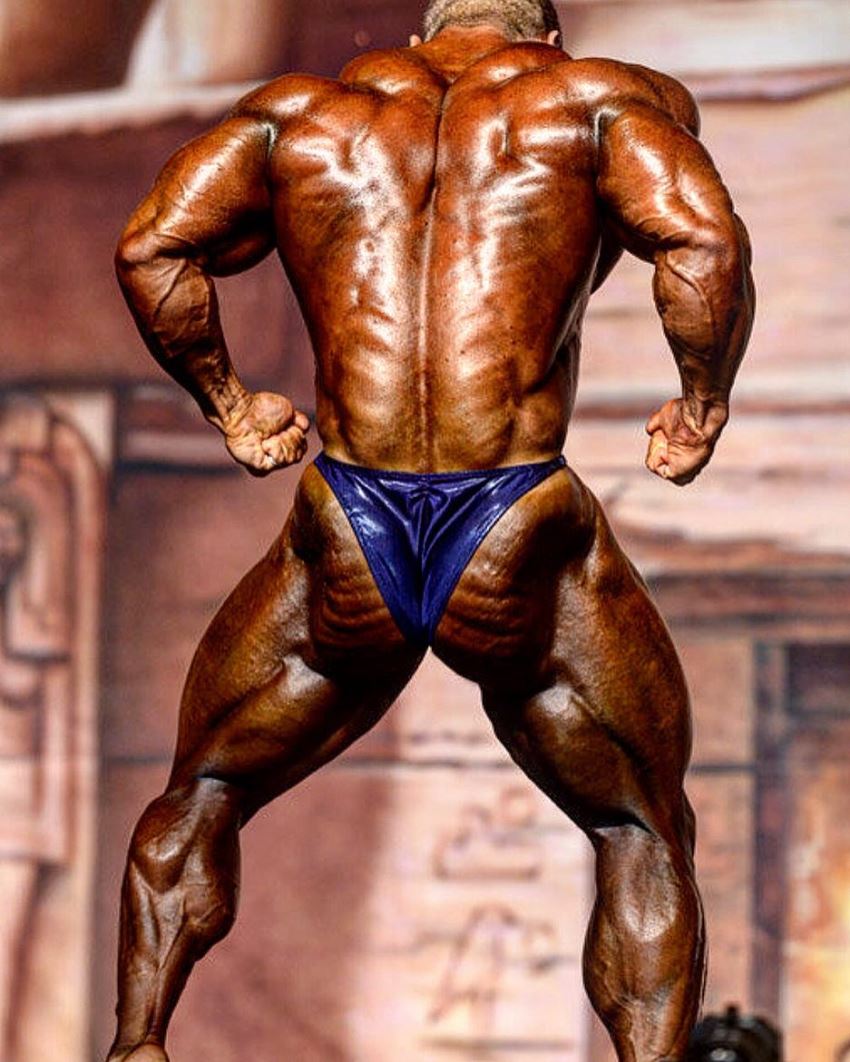 Nicolas Vullioud flexing his ripped back on the bodybuilding stage