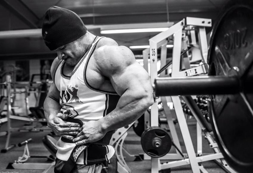 Nicolas Vullioud putting his weightlifting belt on in the gym