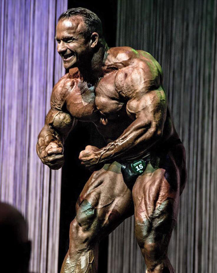 Ronny Rockel flexing his arms on the bodybuilding stage.