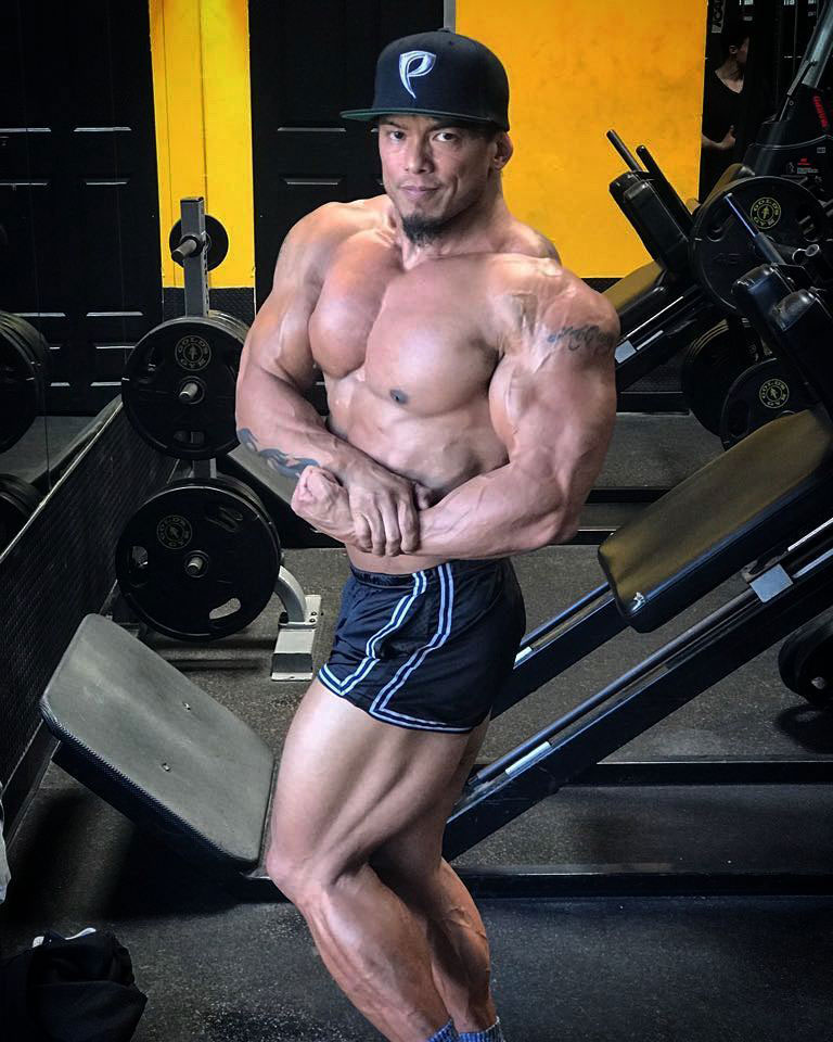 Stan McQuay flexing his bicep in the gym.