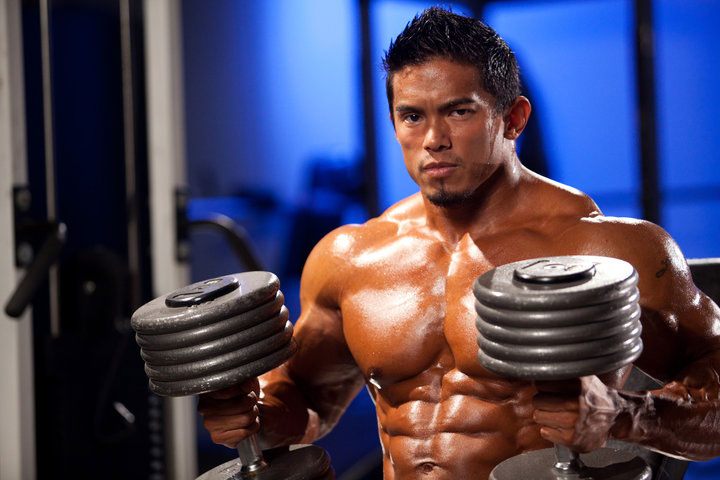 Stan McQuay holding dumbbells in a photo shoot.