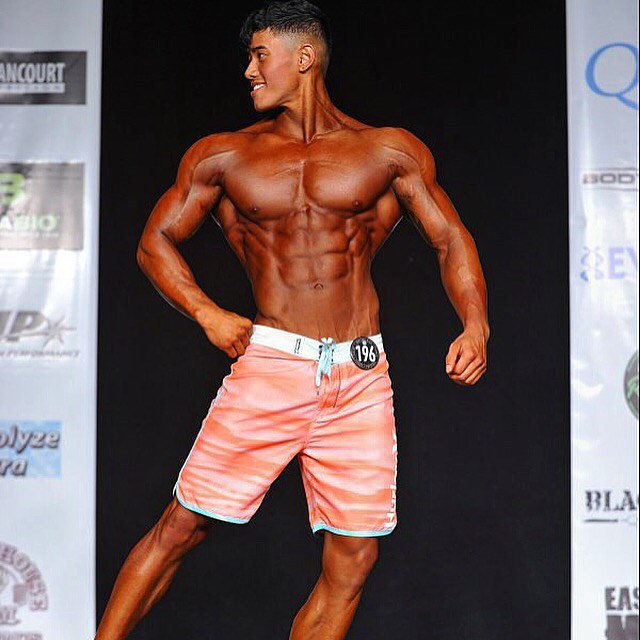 Steven Cao posing on the Men's Physique stage