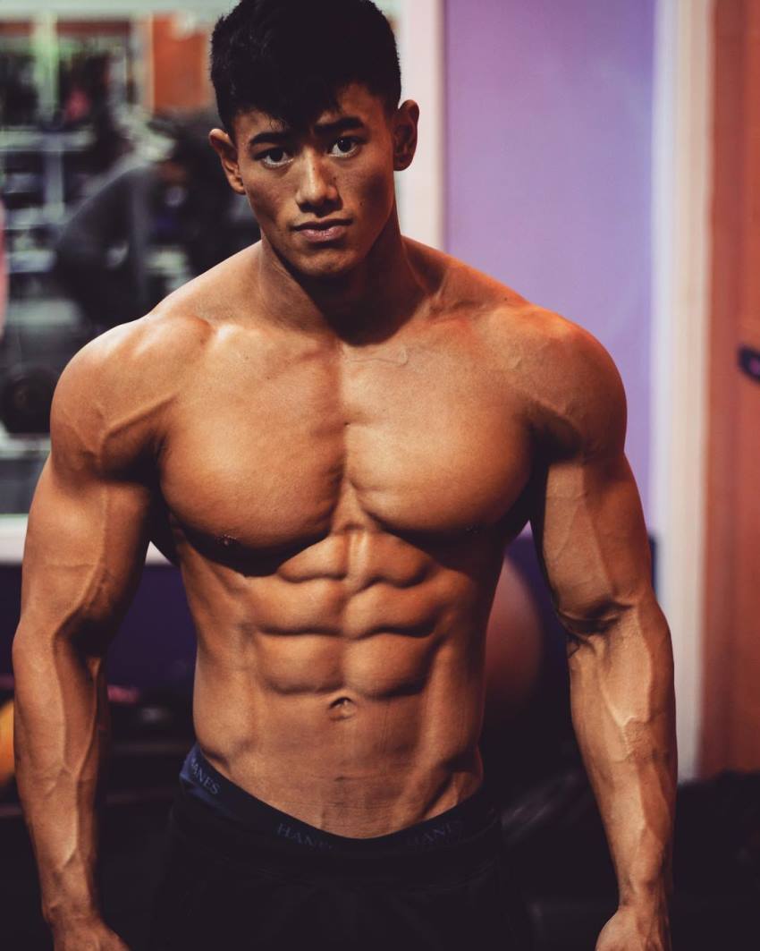 Steven Cao posing shirtless for the photo, looking lean and muscular