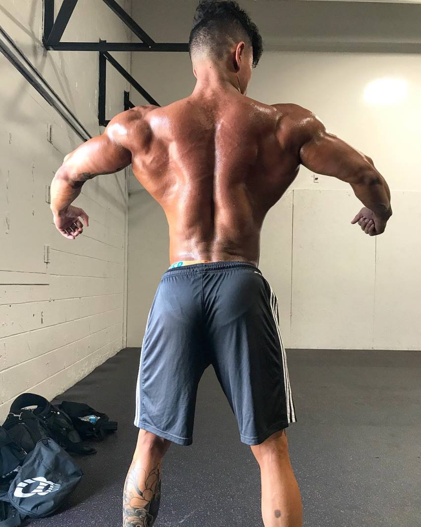 Steven Cao shirtless, spreading his lats wide