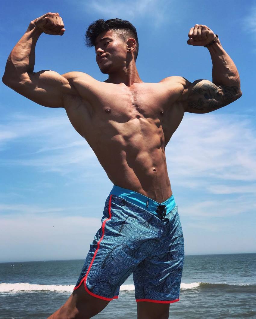 Steven Cao flexing his arms by the sea