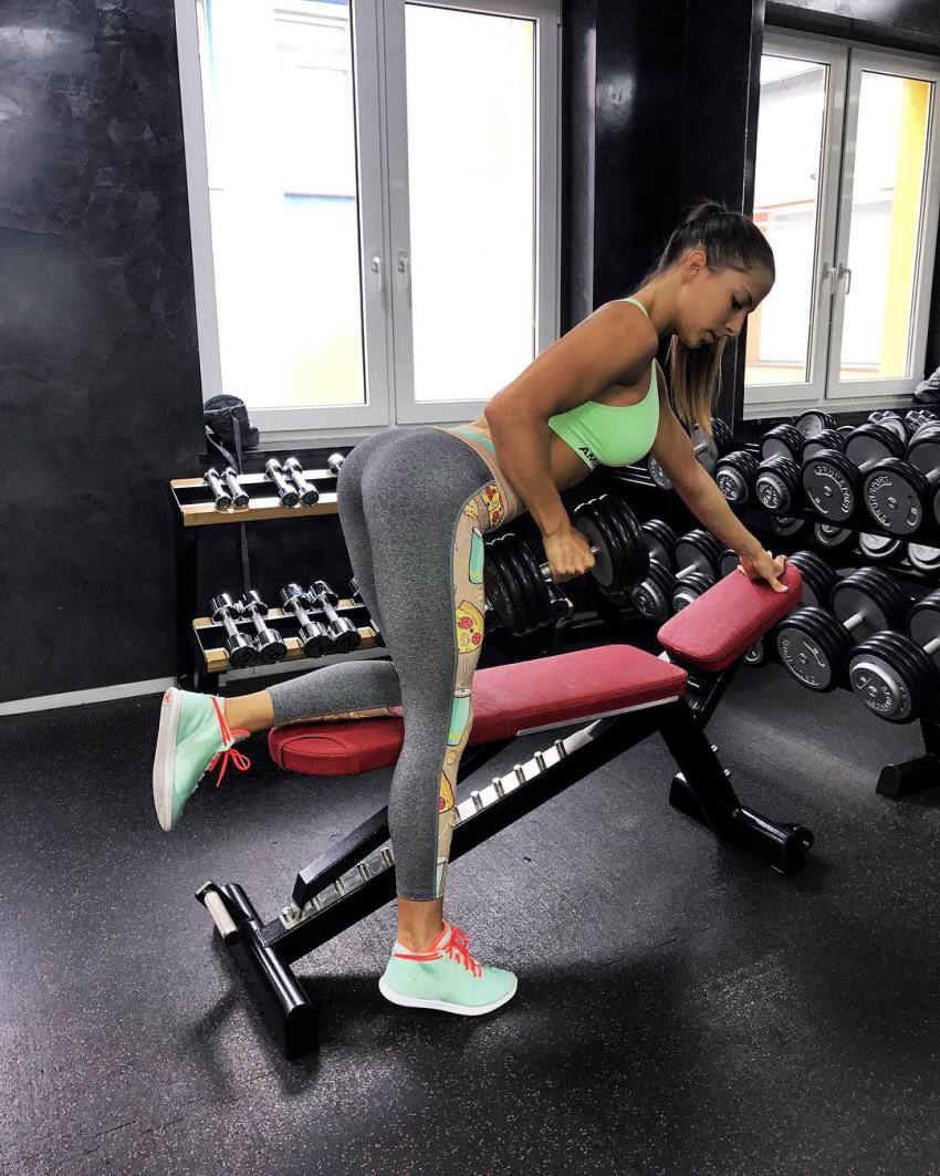 Timea Trajtelova doing dumbbell rows in the gym