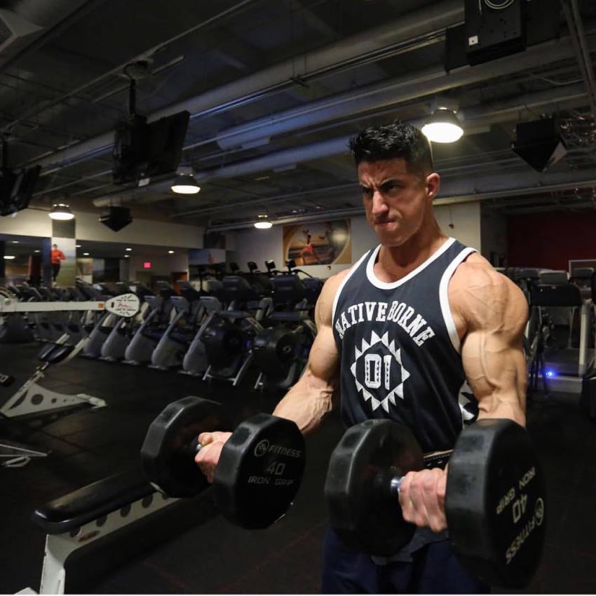 Tomas Echavarria doing dumbbell curls for his strong and ripped biceps