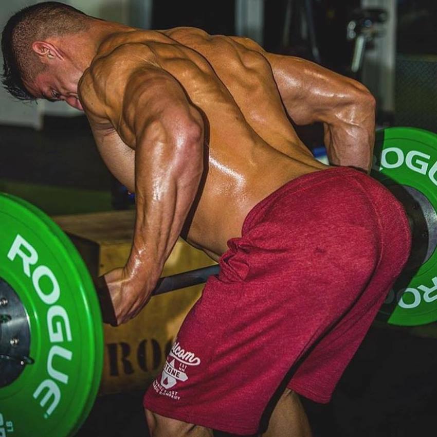 Tomas Echavarria doing heavy barbell rows for back, looking muscular