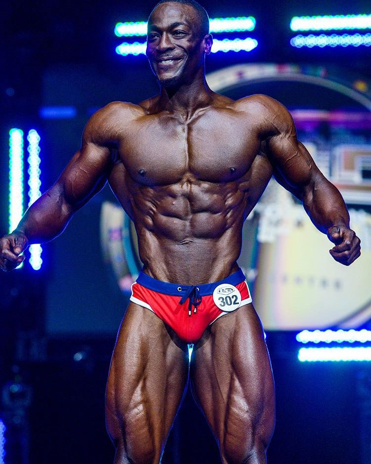 Williams Falade posing on the fitness modelling stage.