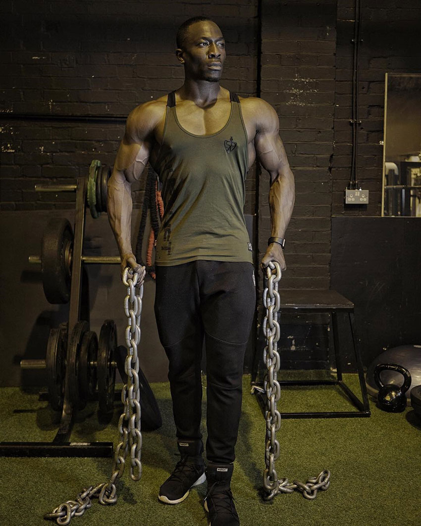 Williams Falade holding chains in the gym.