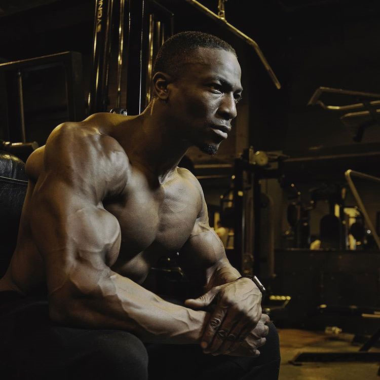 Williams Falade sitting on a bench in the gym.