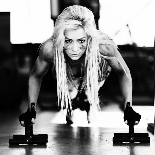 Zoe Daly performing push ups with push up stands.