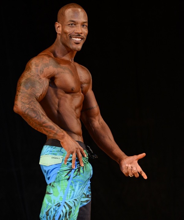 antoine williams flexing on the bodybuilding stage