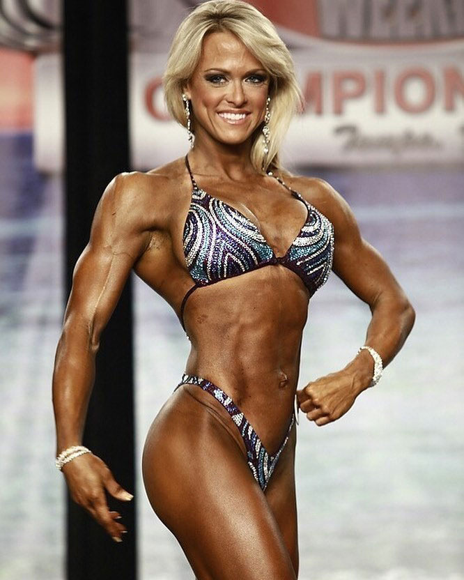 Gennifer Strobo posing on the bodybuilding stage.