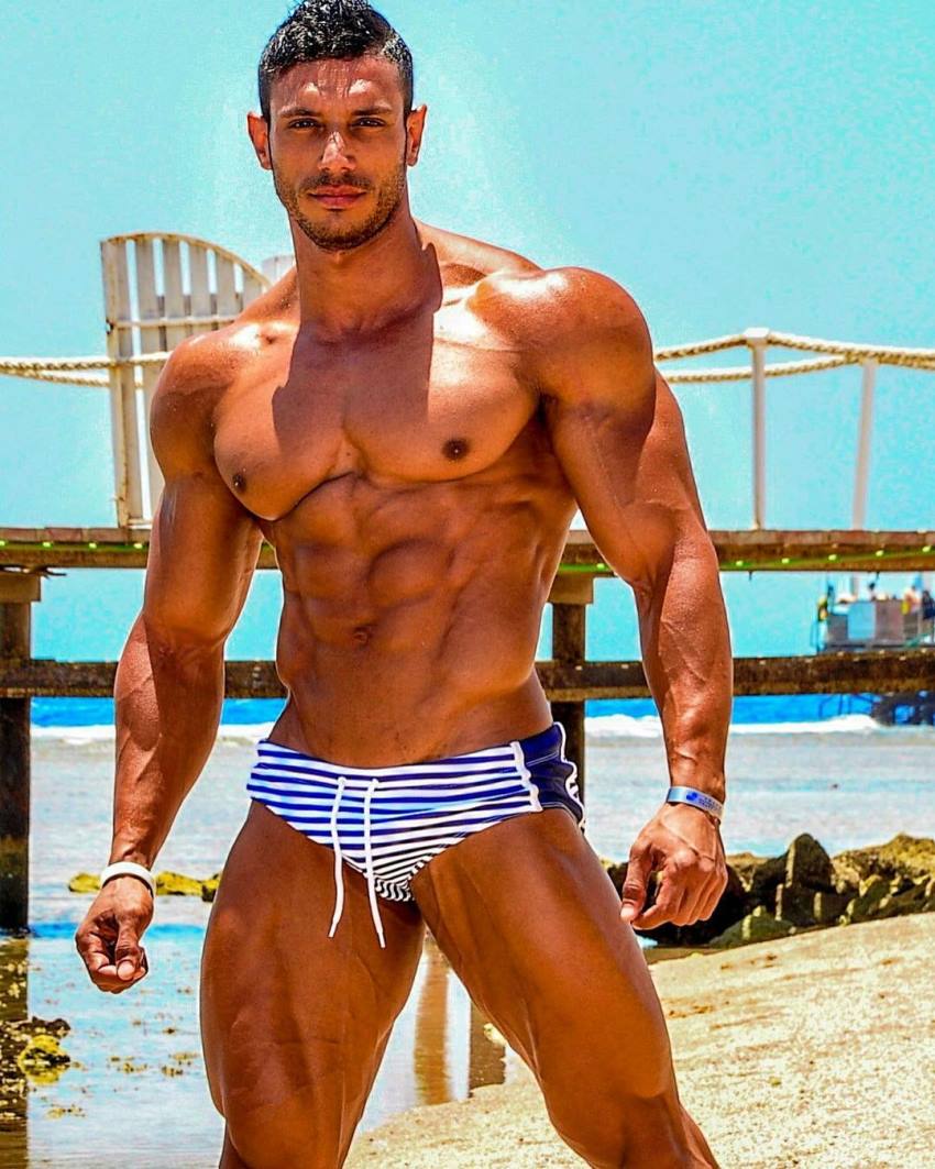 Hany Saeed posing shirtless in a swimsuit, looking ripped and aesthetic