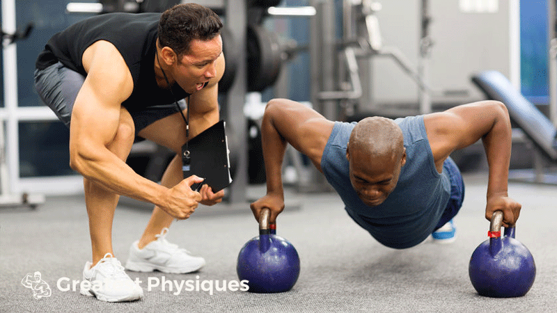 Personal trainer motivates client doing push-ups in gym