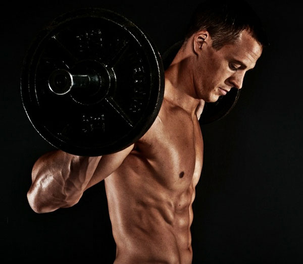 Jeremy Scott holding a barbell on his shoulders.