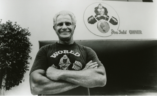 Joe Gold posing for a photo in front of his World's Gym