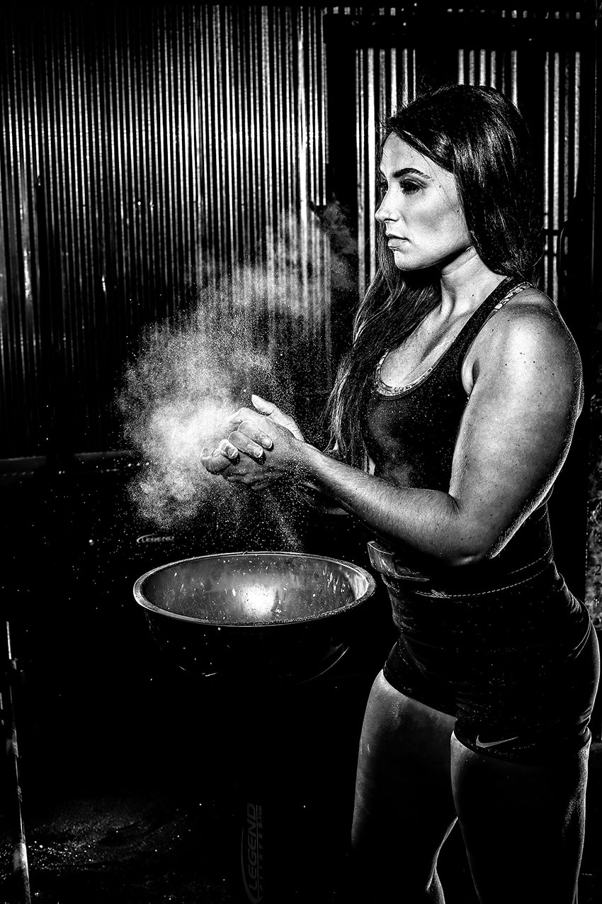 Karina Baymiller putting chalk on her hands in preparation for a lifting session.