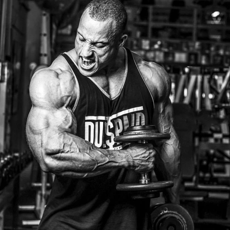 Kevin Jordan doing hammer curls, his arms looking massive and ripped