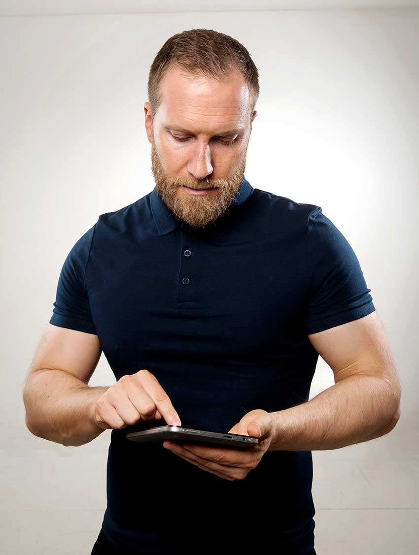 Lee Bell working on an tablet, looking healthy and lean 