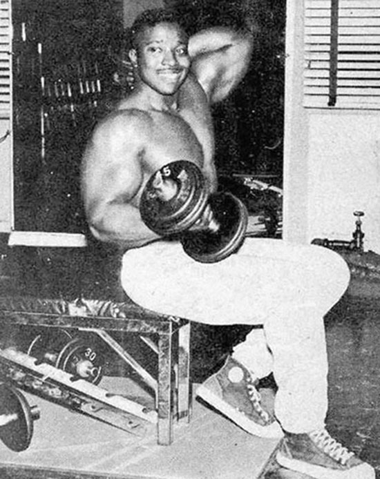 Leroy Colbert in the gym holding a dumbbell.