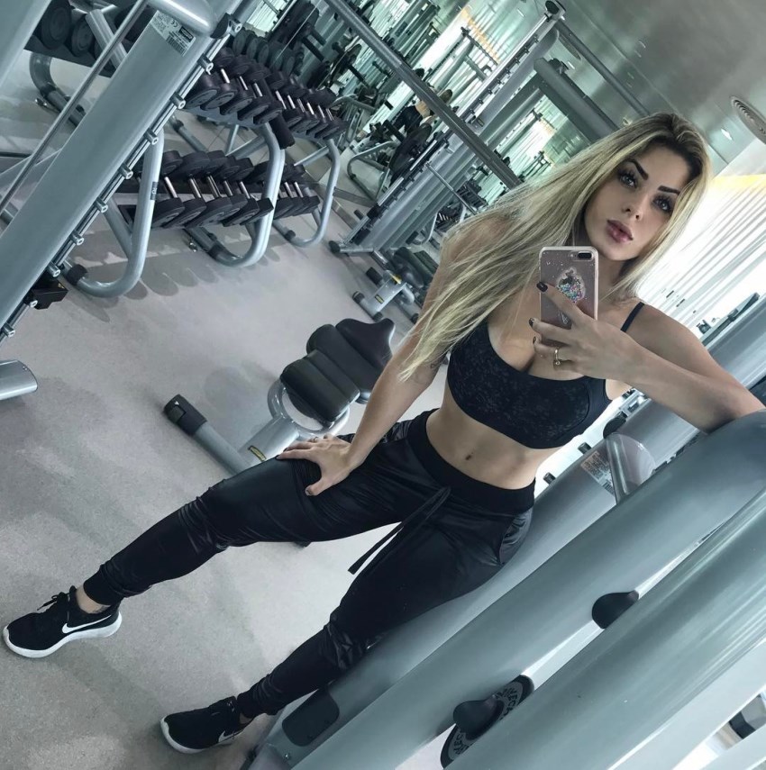 Mariana Castilho taking a selfie of her fit physique in a gym
