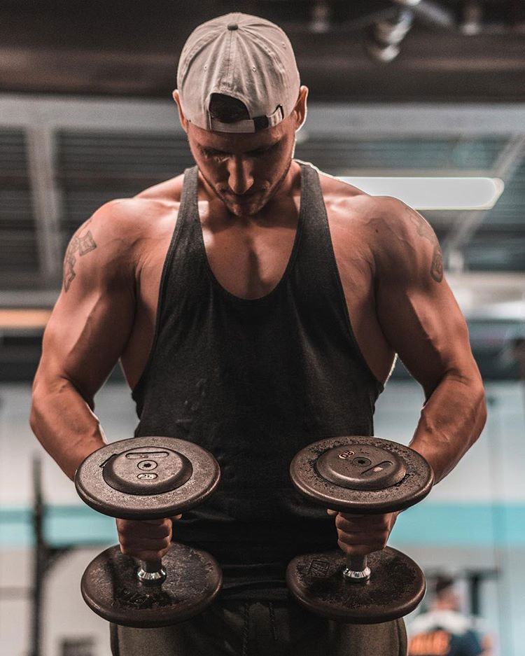 Matty Fusaro holding dumbbells in a photo shoot.