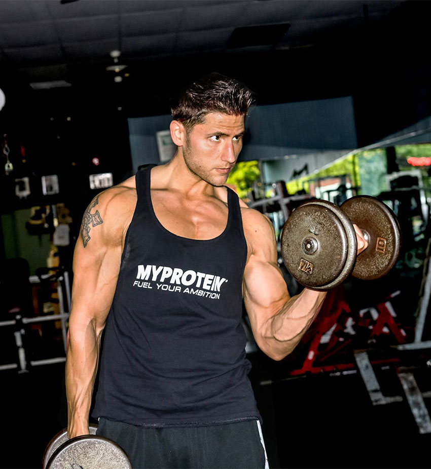 Matty Fusaro performing dumbbell curls in the gym.