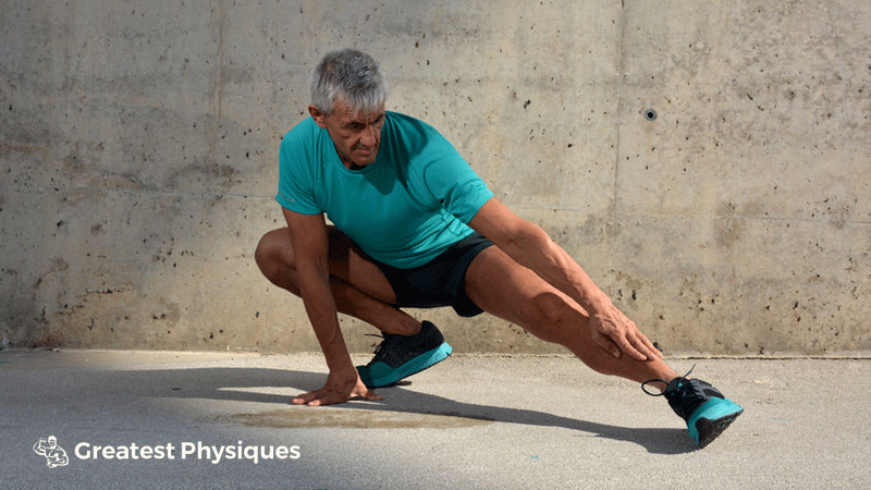 Grey haired, older man stretching before a gym workout outside