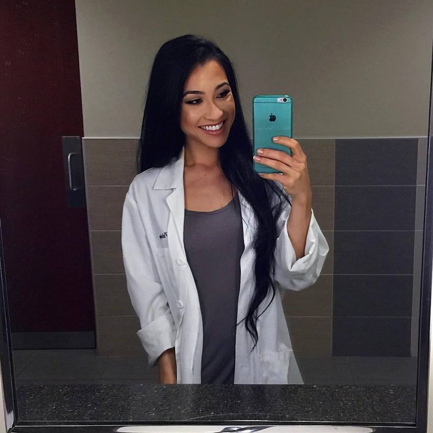 Stephanie Buttermore taking a selfie in her doctor's uniform, looking healthy and fit