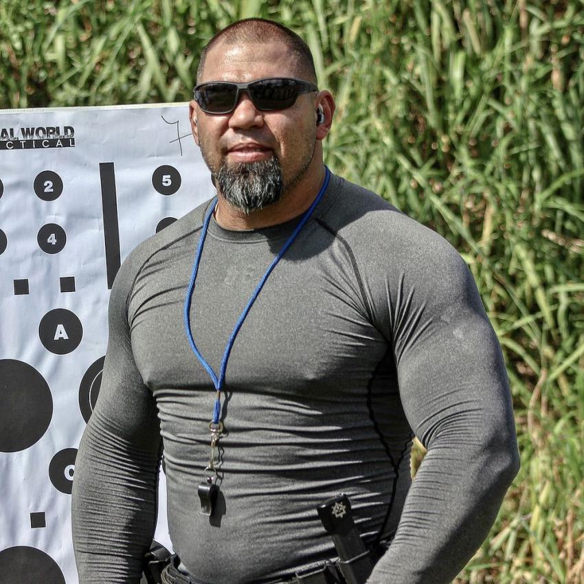 Tony Sentmanat posing for a photo, wearing black sunglasses, looking big and muscular