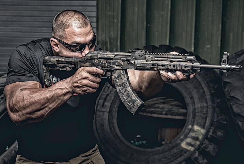 Tony Sentmanat with an AK-47 in his arms at a shooting range practicing his combat skills