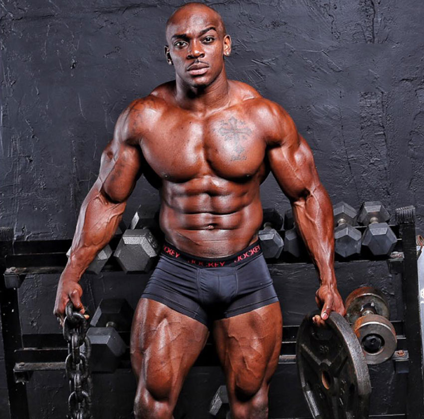 Tyrone Ogedegbe holding a chain and a weight plate in a photo shoot.