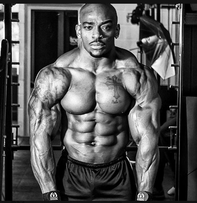 Tyrone Ogedegbe exhibant ses muscles déchirés lors d'une séance photo.