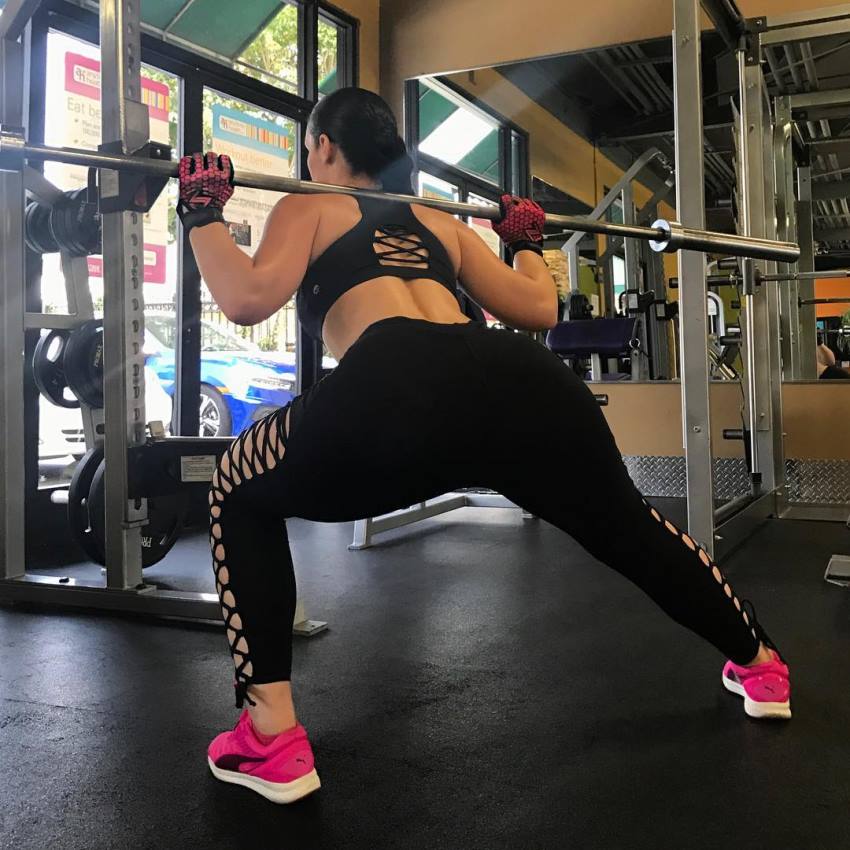 Viktoria Kay doing barbell lunges in a gym